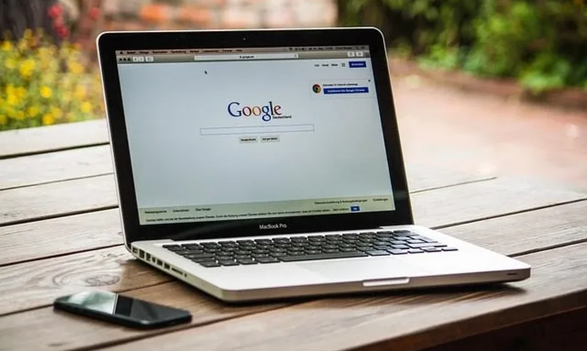 Portátil MacBook Pro en mesa de madera, Google abierto.